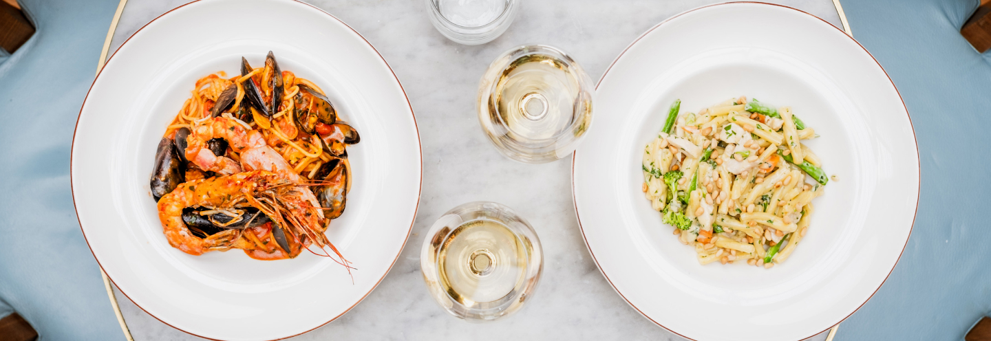 White wine and Italian dishes photographed from above.