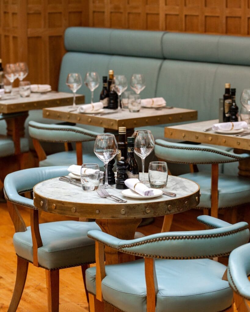 Piccolino Hale Italian restaurant interior with small tables and blue chairs.